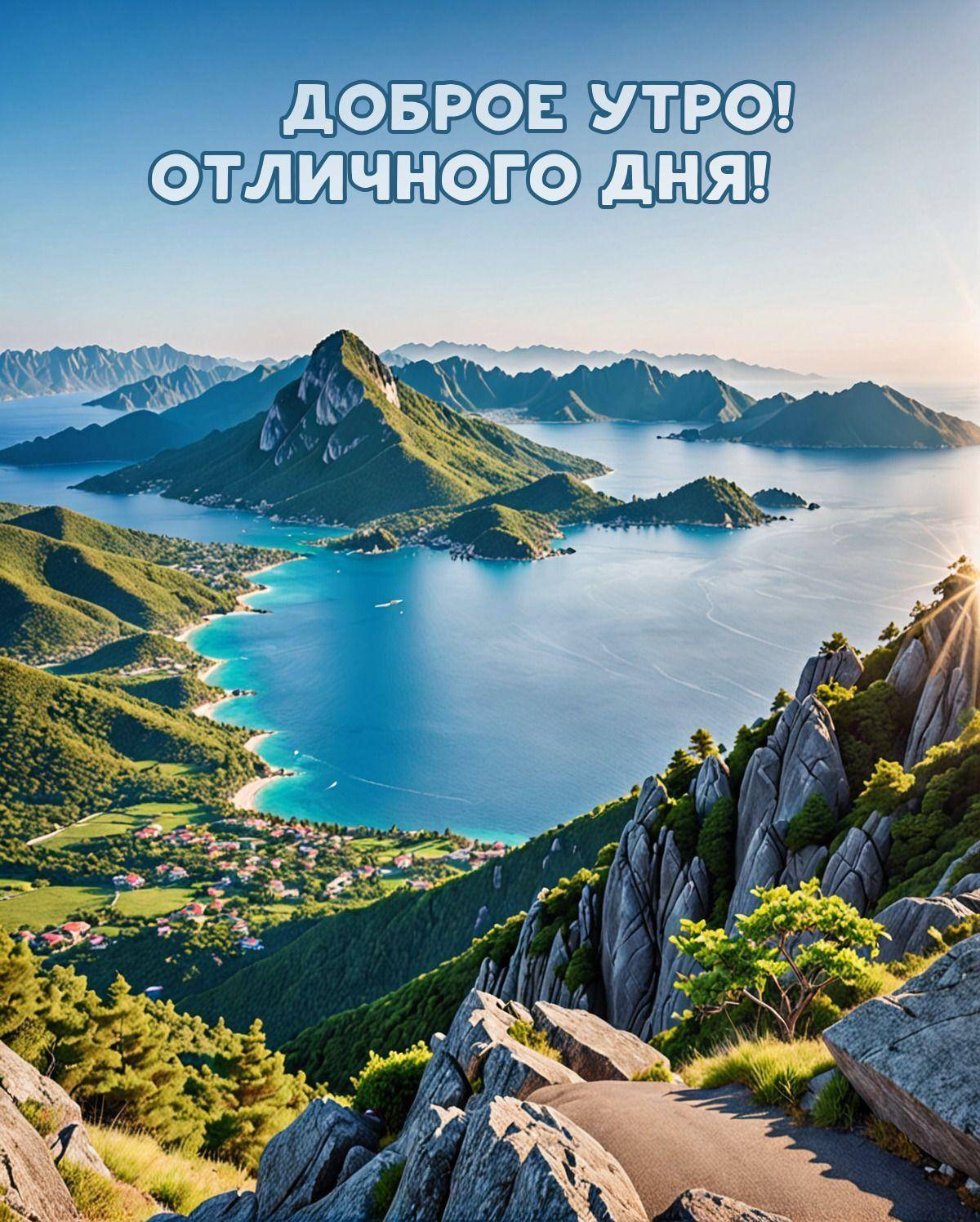 Вид с вершины на залив, горы, зелень и поселок у воды
